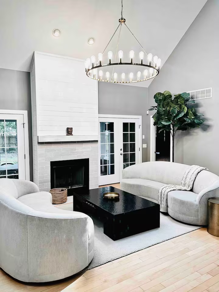 Dramatic living room with fireplace and chandelier at Spacious Modern Hideaway